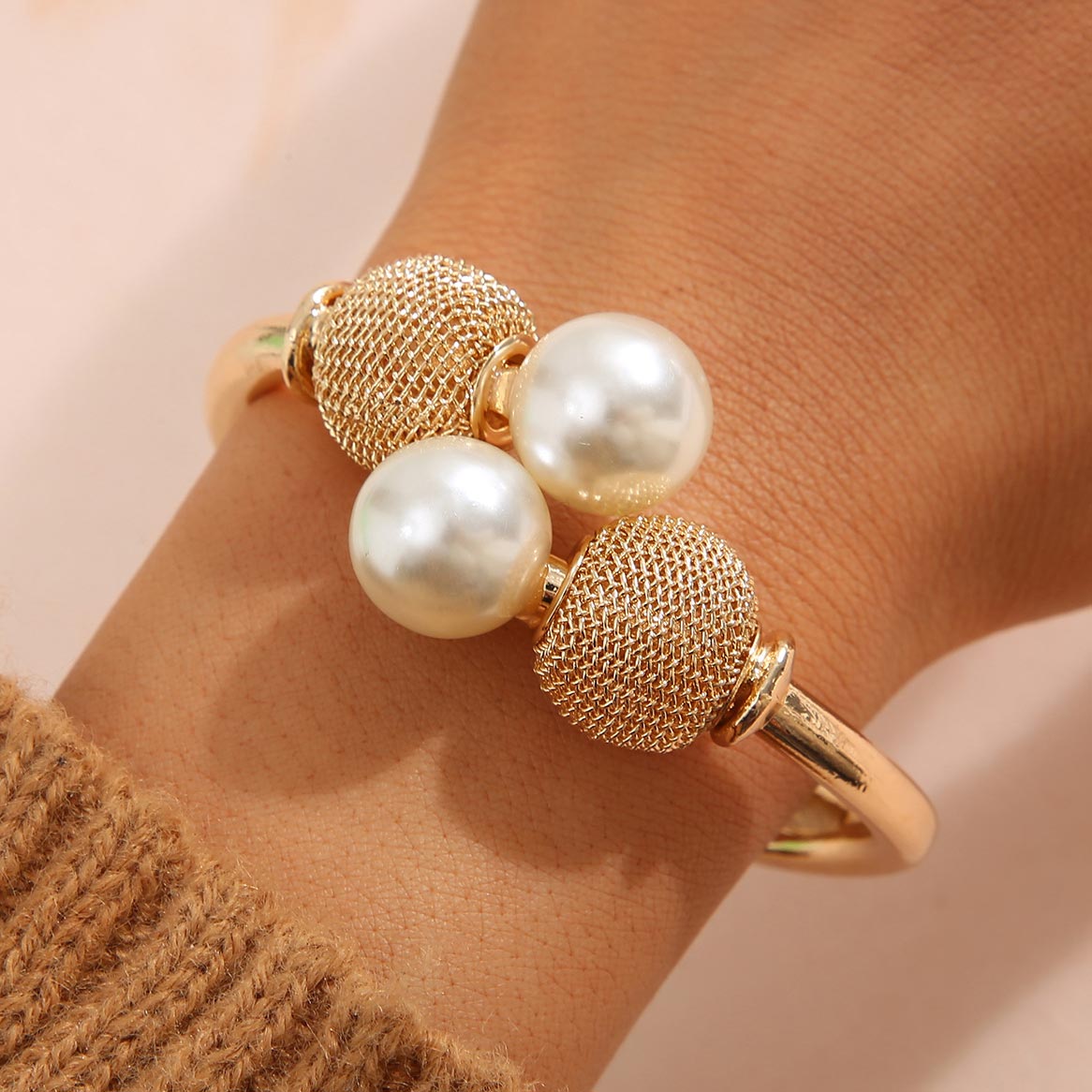 Bracelet ouvert avec perles dorées et détail en métal