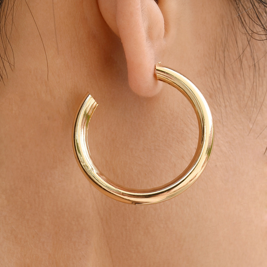 Runde goldene Ohrringe mit geometrischem Muster und Metalldetail
