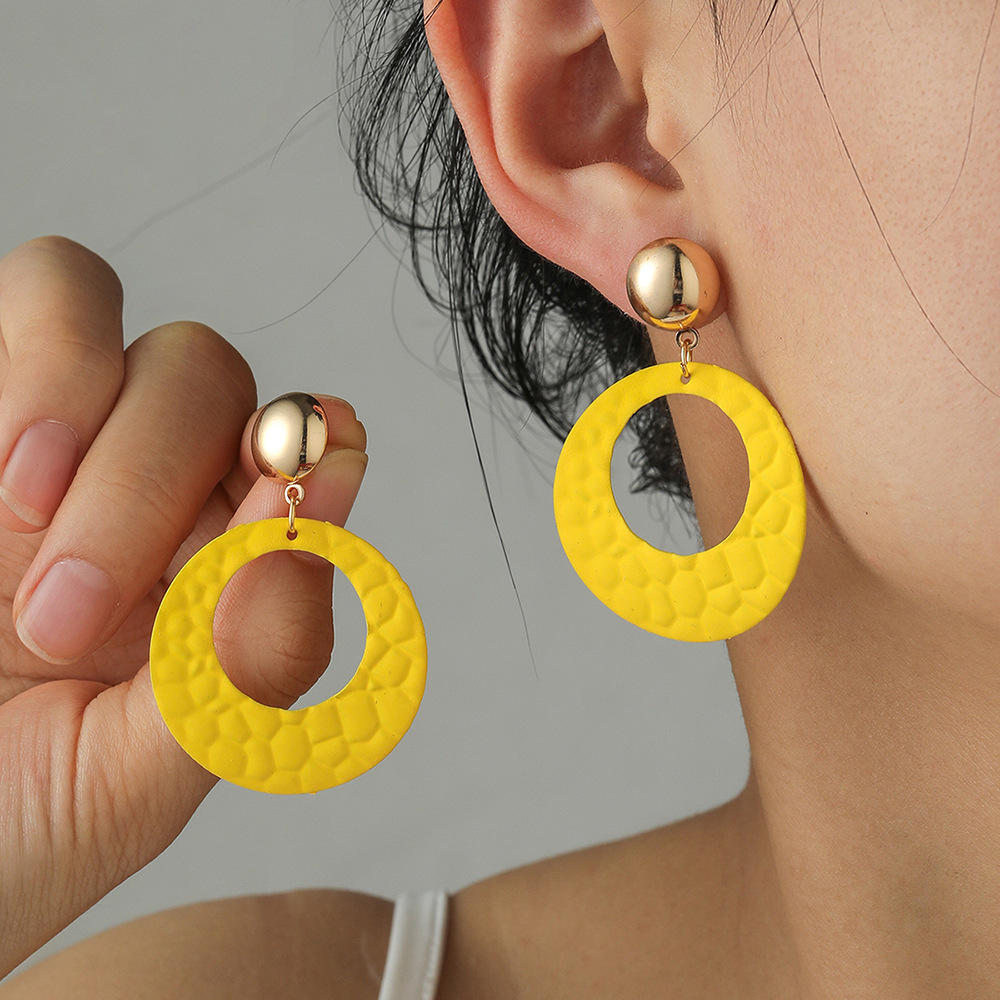 Runde gelbe Ohrringe mit Metalldetail und Ausschnitt