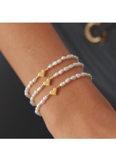 Set aus weißem Perlenarmband mit Herzmotiv